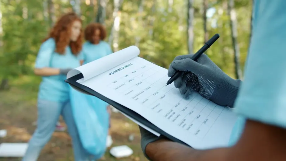 Volunteers recording data during a forest clean-up, promoting environmental awareness.